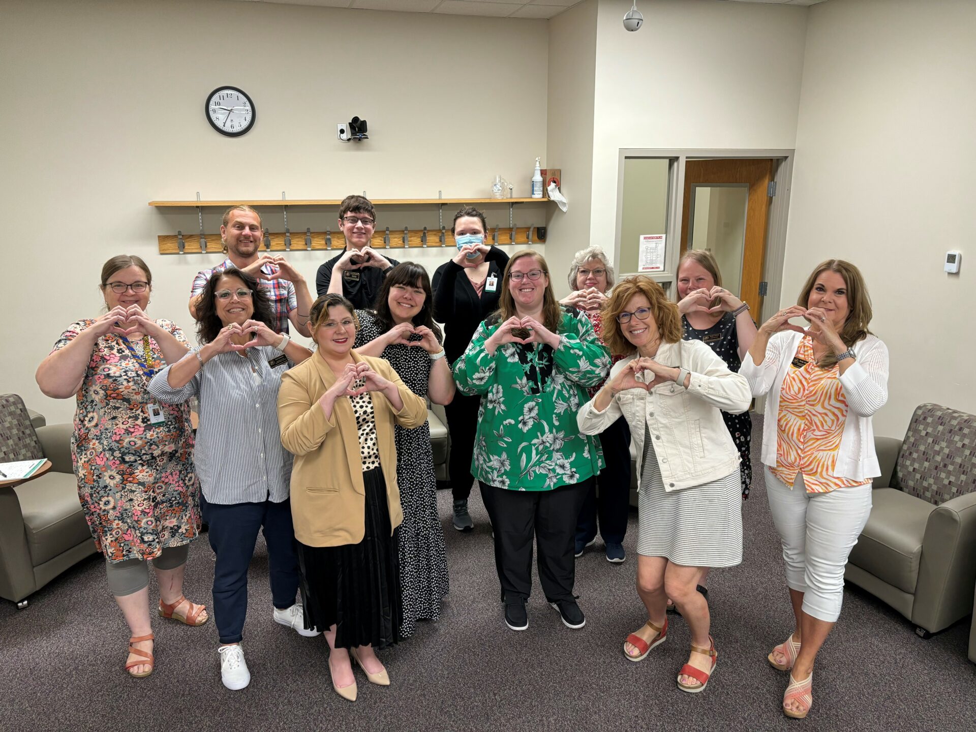 JWCC staff participating in Caring Campus pose with heart-hands