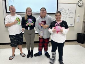 4 College for Life students smile with their sewing creations